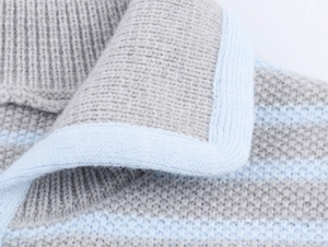 Vista macro dettagliata del gilet in maglia a righe grigie e azzurre con trama in lana