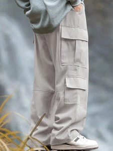 Dettaglio delle tasche cargo e della trama del tessuto dei pantaloni larghi da uomo