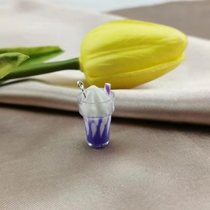 Detailed macro shot of a purple mini ice cream pendant on elegant silk fabric