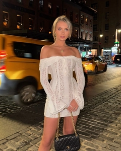 Close-up of white lace mini dress with off-shoulder neckline and flared bell sleeves
