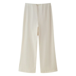 Detail of high waist cream wide leg trousers with vertical pleated texture and straight cut