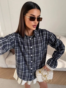 Detail of dark blue plaid shirt with lace cuff stitching and classic collar design