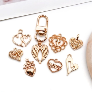 Golden heart-shaped metal charms featuring LOVE letters and wing designs for DIY jewelry