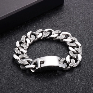 Gros plan d'un bracelet gourmette argenté serti de zircons cubiques sur fond noir mat