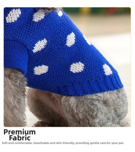 Detail of royal blue knitted dog sweater with white polka dots and soft texture