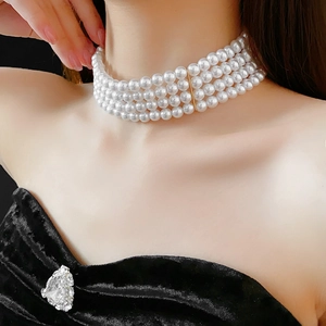 Détail d'un collier de perles élégant à quatre rangs avec accents dorés sur un mannequin