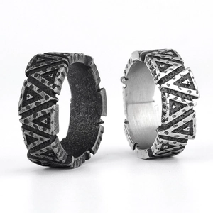 Macro detail of Viking style stainless steel rings with geometric vertical textures