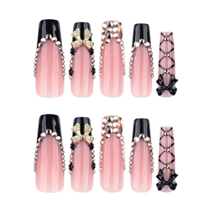 Gothic black French tip press-on nails with long coffin shape, bows, and sparkling rhinestones