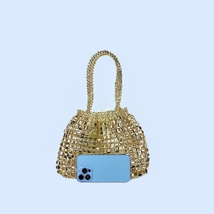 Close-up of golden metallic woven tote bag with hollow-out mesh design and sequins