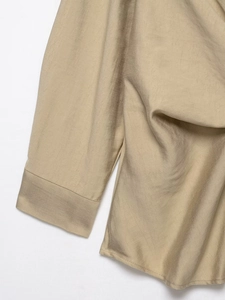 Detailed close-up of khaki woven fabric texture on the shirt sleeve and hem craftsmanship