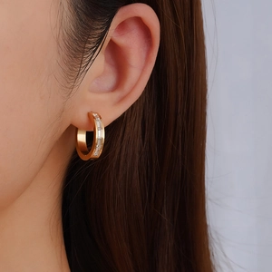 Classic gold hoop earrings for women with inlaid baguette zircon stones on model