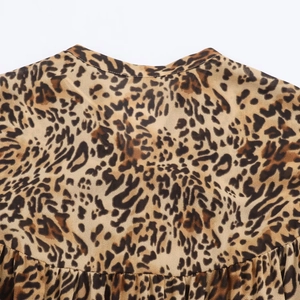 Dettaglio dello scollo dell'abito leopardato con cuciture fini e trama del tessuto