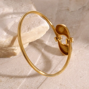 Minimalistische gouden roestvrijstalen open armband met druppeldesign op natuursteen
