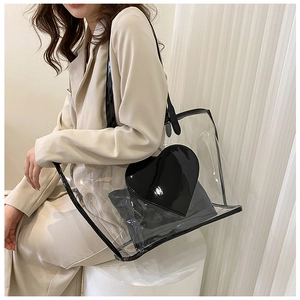Close-up of transparent PVC tote bag with black heart detail and matching inner pouch