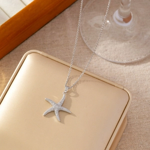 Bohemian silver starfish pendant necklace with white zircons on a luxury jewelry box
