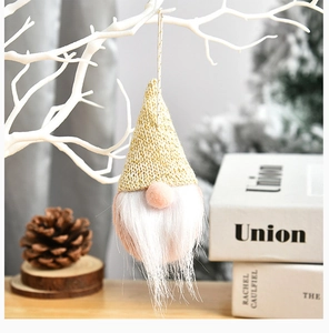 Detail of Christmas gnome ornament with gold knitted hat and pink nose on white branches