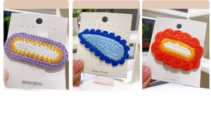 Detailed view of handmade crochet hair clips in purple, blue, and orange floral designs