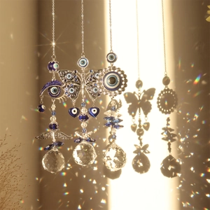 Close-up of crystal suncatcher with evil eye charms and rainbow light reflections