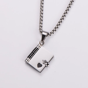 Macro view of silver stainless steel book-shaped locket with heart-shaped cutout
