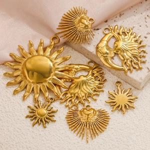 Detailed view of sun and moon gold charms on silk and stone backgrounds for DIY jewelry
