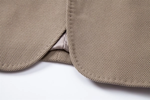 Gros plan du blazer kaki montrant la texture tricotée en nid d'abeille et les coutures nettes