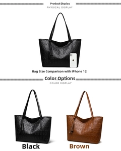 Size comparison between a large skull-embossed tote bag and an iPhone 12 with tassels