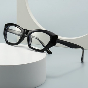 Occhiali da sole cat-eye moderni con montatura spessa nera su un supporto bianco minimale