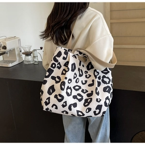 Détail du grand sac cabas en toile à imprimé léopard avec bretelles kaki à l'épaule