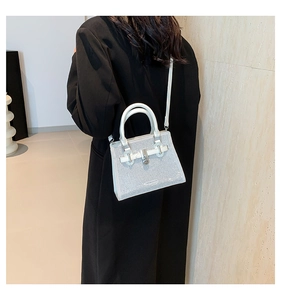 Close-up of stylish silver sequin handbag featuring a twist lock and double handles