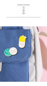 Close-up of Smile capsule and Cheer Up enamel pins on a dark blue canvas bag texture