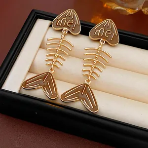 Minimalist gold and brown fishbone earrings with 'me!' engraving in a premium jewelry box