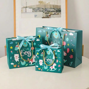 Three teal 'It's a Boy' gift bags in varying sizes with baby illustrations and gold handles