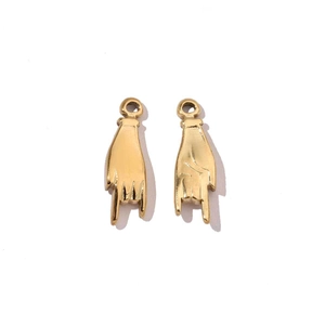 Detailed macro view of gold mirror-polished rock-on hand gesture pendants in stainless steel