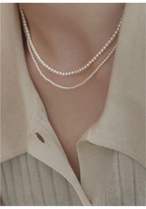 Close-up of double-layer freshwater pearl necklace with 14K gold-filled accents on a model