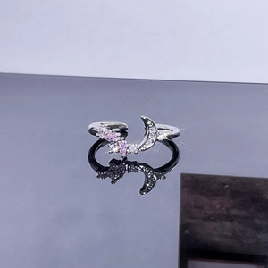 Macro detail of adjustable silver ring with moon motif and pink zircon accents