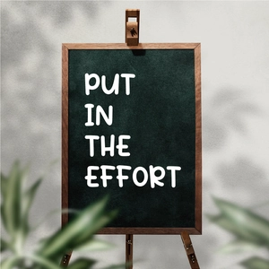 Close-up of a mini tabletop chalkboard with a wooden easel and inspirational quote