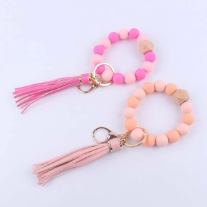 Silicone and beech wood beaded keychain bracelet with leather tassel in pink and orange