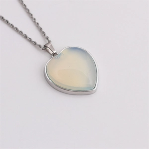 Detail of silver twist chain necklace with heart-shaped moonstone pendant macro view