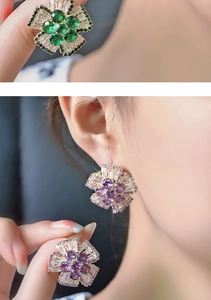 Detailed macro view of purple and green floral stud earrings with radiant cubic zirconia