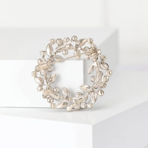 Macro shot showing the silver-toned floral wreath brooch with pin backing detail