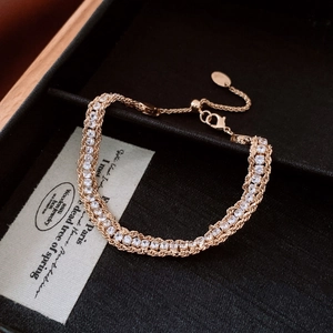 Detailed close-up of rose gold entwined chain bracelet with sparkling zircon stones