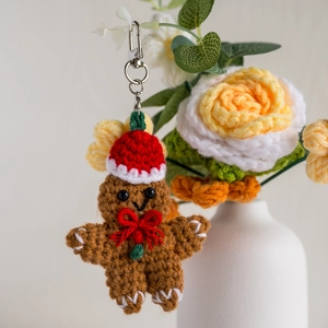 Handmade crochet gingerbread man keychain with festive Christmas hat and red bow tie