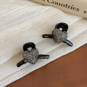 Set of two heart-shaped mini hair claws with dark grey rhinestones on black base