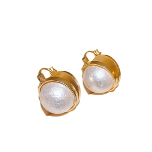 Boucles d'oreilles perles baroques rétro avec cerclage en métal doré sur fond blanc