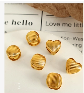 Vue détaillée de boucles d'oreilles en titane doré aux textures géométriques rayées
