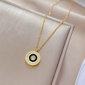 Detail of gold titanium steel necklace with a crystal-encrusted circular pendant