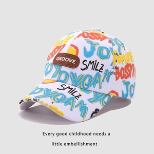 Détail d'une casquette enfant avec imprimés graffiti colorés et écusson GROOVE en cuir brun