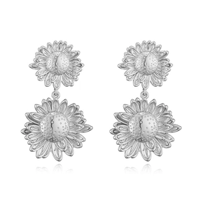 Macro view of silver sunflower earrings featuring tiered petals and textured center details