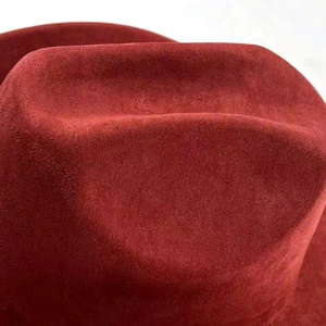 Close-up of the burgundy suede fabric and textured crown of this Western cowboy hat