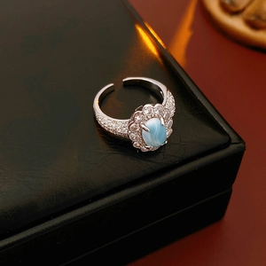 Macro shot of a silver gourd ring featuring a light blue oval stone and zircon accents